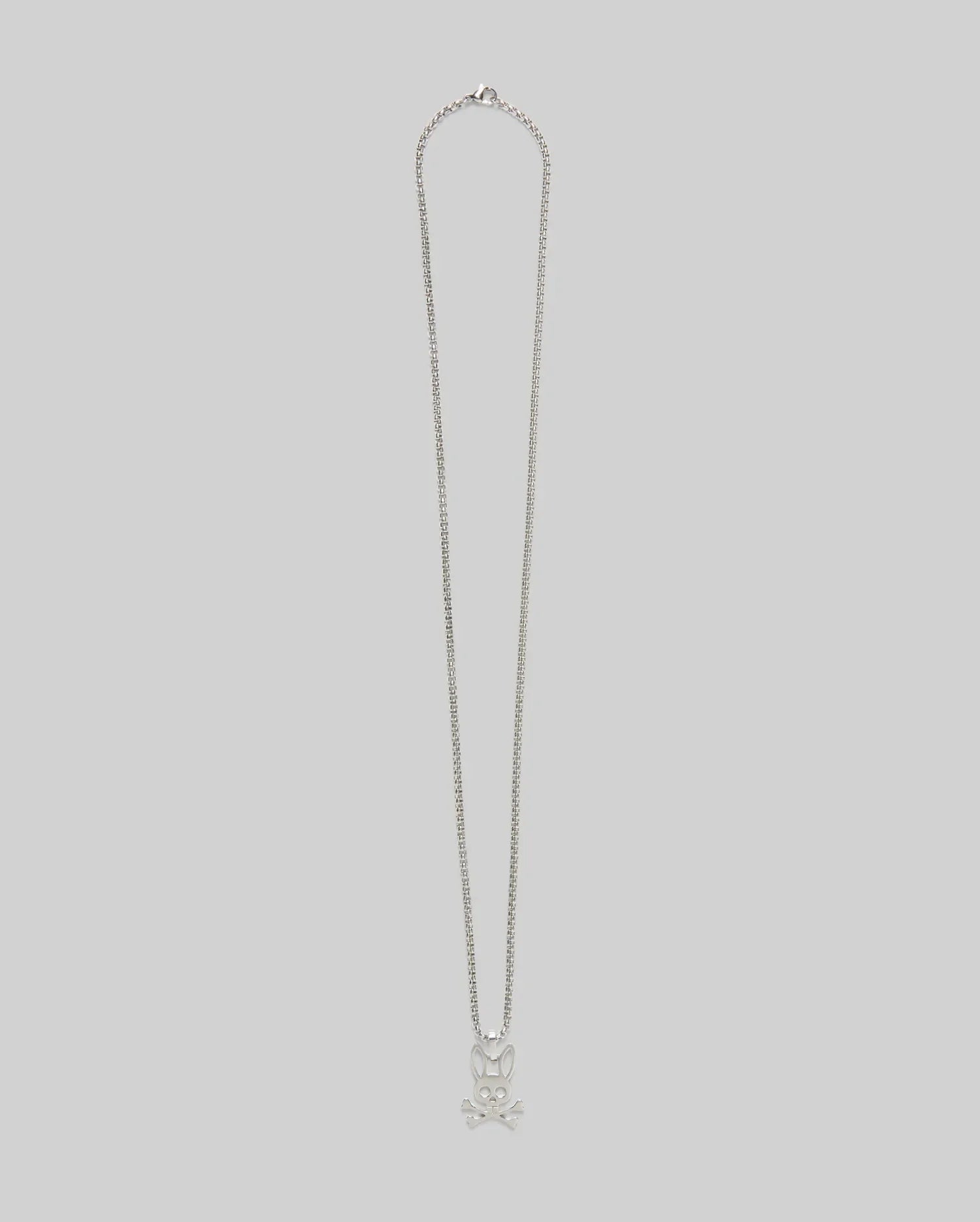 The MENS BUNNY NECKLACE - MO1700022 by Psycho Bunny features a steel pendant with a skull and crossbones design, set against a plain light gray background.