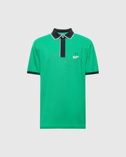 The Psycho Bunny MENS CLAYTON PIQUE POLO (MT0100004) is a green polo shirt made from Pima cotton, featuring colorblocking with a black collar, white-trimmed placket, and short sleeves for breathability. A small flag logo is embroidered on the left chest against a plain white background.