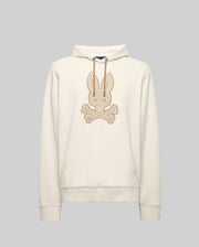 The Psycho Bunny MENS RYDER BUNNY HOODIE (MT0500029) is a cream hoodie with a large beige embroidered Bunny skull-and-crossbones patch, drawstring hood, and kangaroo pocket—ideal for lounging. Shown against a plain gray background.