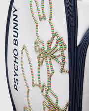A close-up of the OUTLINE BUNNY GOLF TOUR BAG - PBMG4FC1 from Psycho Bunny shows its white polyurethane build with dark blue accents, a vibrant 3D bunny design in coiled strings, and features like zippers and five-pocket club dividers for easy organization on the course.