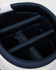 Close-up of the OUTLINE BUNNY GOLF TOUR BAG - PBMG4FC1 by Psycho Bunny. Its polyurethane cart bag interior has multiple blue cushioned dividers to organize and protect clubs. The stylish outer edge is white, featuring a five-pocket design.