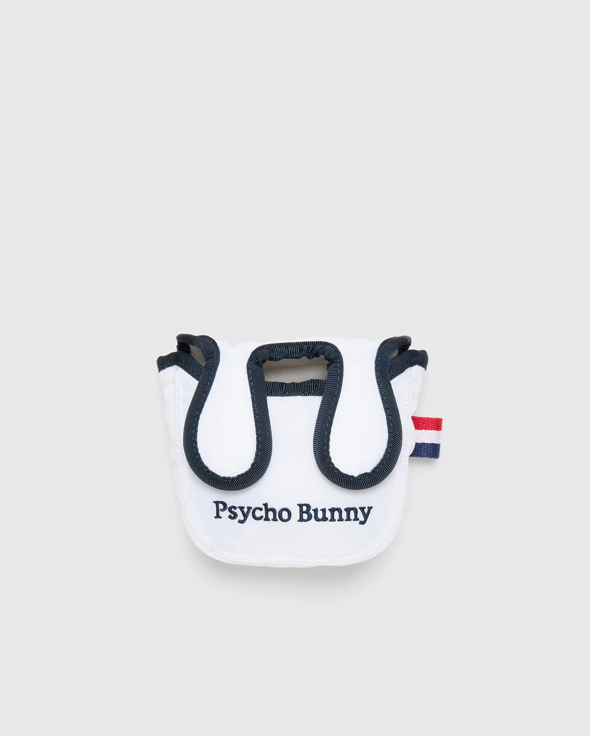 The MULTI BUNNY MALLET PUTTER COVER - PBMG4SH6 by Psycho Bunny is a small white pouch with black trim, featuring a red and blue striped tab, perfect as a golf accessory. The front is embroidered with "Psycho Bunny" in black. It has a rounded top flap and minimalist design ideal for mallet putters.