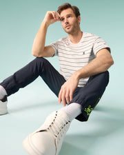 Male model sitting on the ground wearing the mens pima cotton alton stripe heavy weight tee holding his head up with one arm resting on his knee