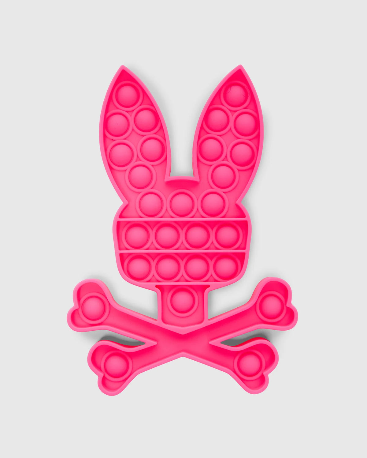 The PSYCHO BUNNY POP IT - B0A376E200 by Psycho Bunny is a bunny-shaped pop-it fidget toy made from premium silicone, featuring a pink rabbit head with long ears atop crossed bones in a skull-and-crossbones design.