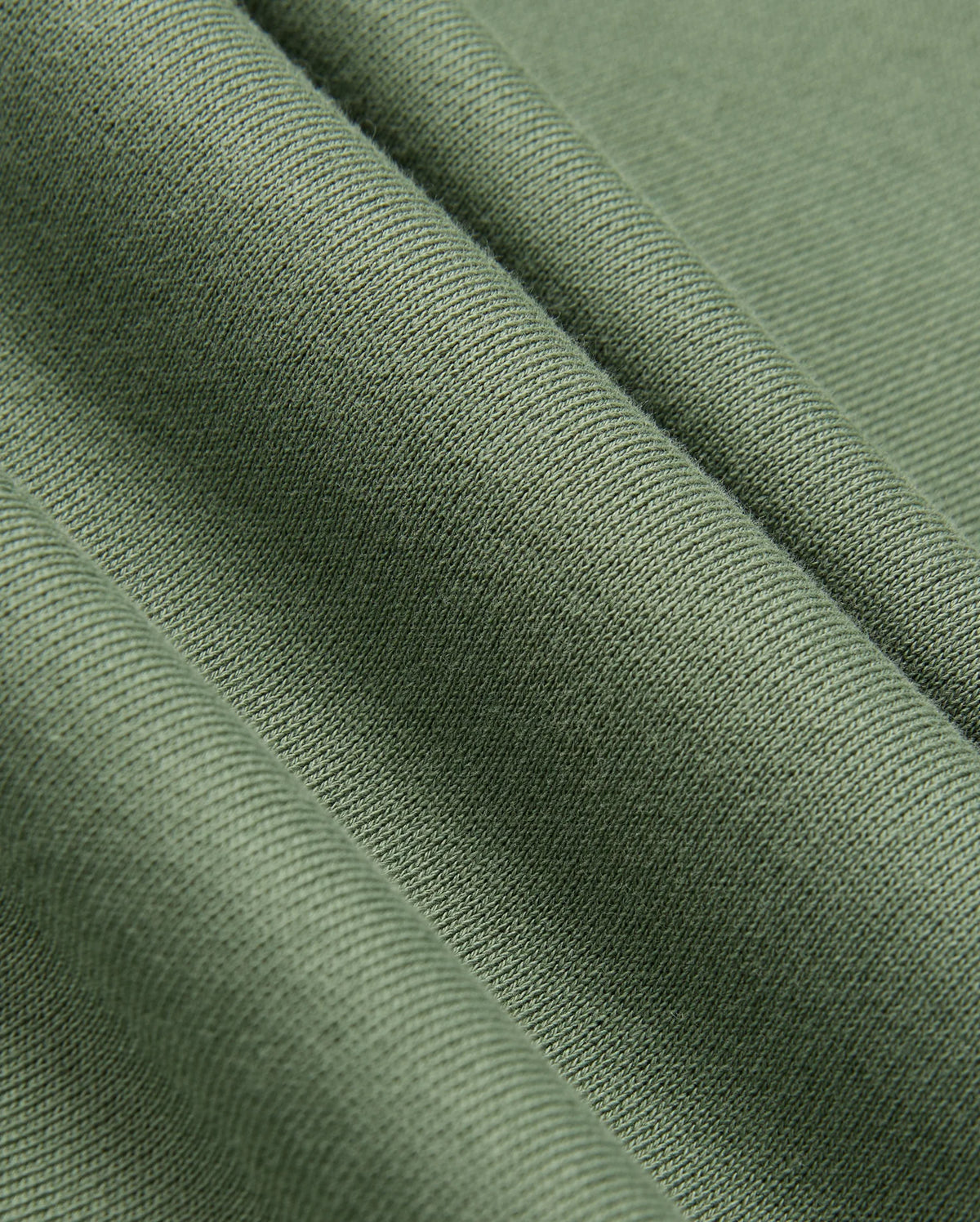 A close-up of olive green fabric with a ribbed texture, reminiscent of the KIDS PACIFIC CHENILLE HOODIE by Psycho Bunny. The fabric falls into soft folds, accentuating its smooth and slightly shiny surface similar to the chenille embroidery on this Psycho Bunny piece.