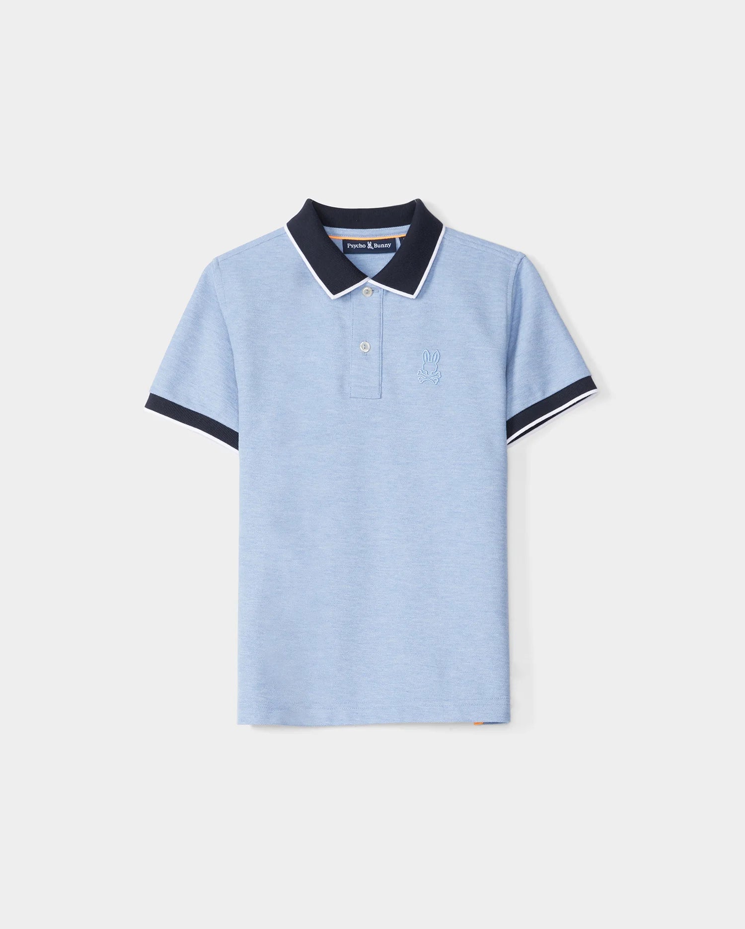 A KIDS WINDCREST PIQUE POLO SHIRT - B0K592C200 in light blue with a color blocked collar and sleeve trim. The dark blue collar features a white stripe on the edge, and the shirt has two buttons at the neckline. A raised-embroidered chest Bunny adorns the left chest area, set against a plain white background by Psycho Bunny.