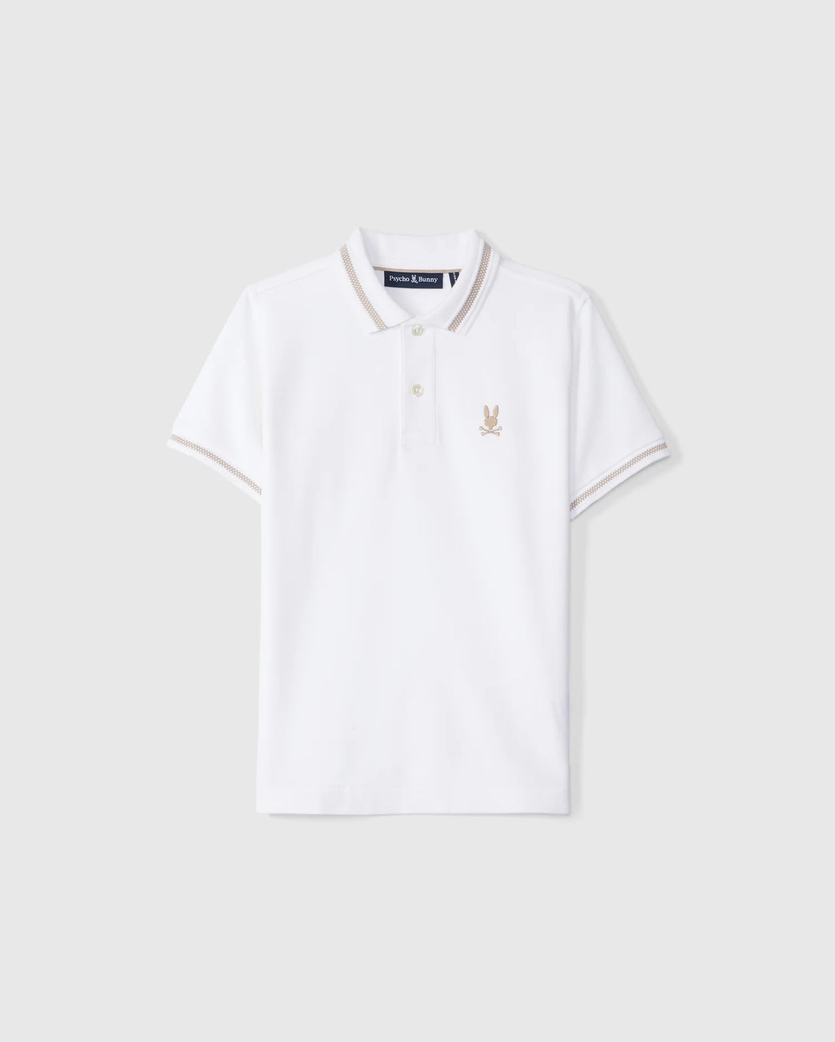 The Psycho Bunny KIDS RIVIERA PIQUE POLO SHIRT - B0K640C200 is a white short-sleeved polo shirt made from Pima cotton. It features a small embroidered Bunny logo on the left chest, a classic collar with a two-button placket, and contrasting beige trim on the collar and sleeve cuffs.