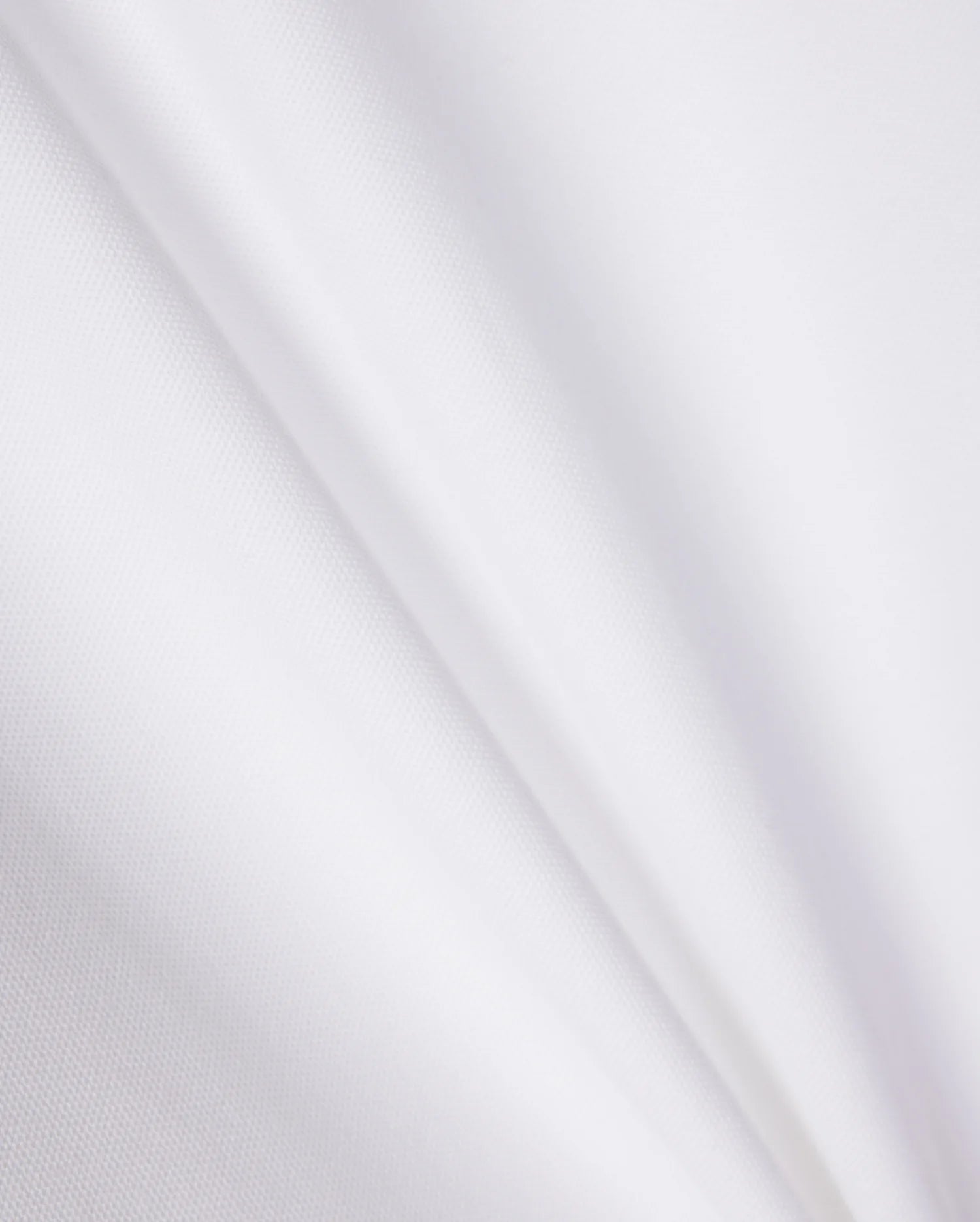 A close-up of a smooth, white Pima cotton fabric with subtle, diagonal creases. The texture appears soft and light, showcasing the clean and pristine appearance of the KIDS RIVIERA PIQUE POLO SHIRT - B0K640C200 by Psycho Bunny, reminiscent of a refined Riviera polo.