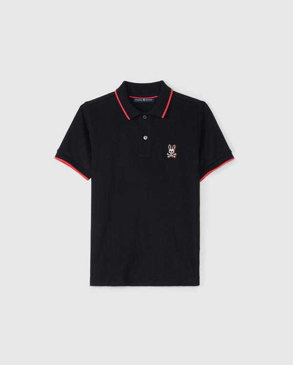 The KIDS KAYDEN PIQUE POLO - B0K675C200 by Psycho Bunny is a black polo shirt accented with red trim on the collar and sleeve cuffs. It has a small, white, embroidered rabbit logo on the left chest. Crafted from Pima cotton piqué, this shirt features a two-button placket and is showcased against a plain white background.