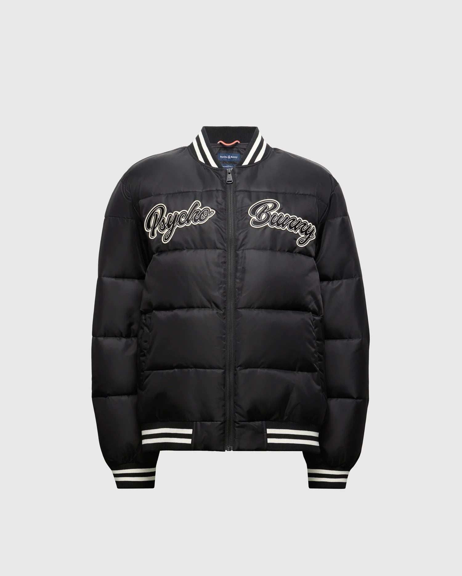 Check out the KIDS FRASER FASHION PUFFER (B0N338E200) from Psycho Bunny for your child. This trendy black jacket showcases white "Psycho Bunny" lettering on the front and includes a zip closure, along with striped ribbed cuffs and collar, making it an ideal choice for keeping your child stylish and warm.
