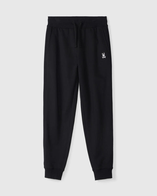 The KIDS LEVY ESSENTIAL FLEECE SWEATPANT - B0P721D200 by Psycho Bunny is a pair of black, 100% cotton sweatpants with an elastic waistband and drawstring, featuring a small white embroidered bunny logo on the left thigh. These cozy playtime pants have cuffed ankles and side pockets, making them ideal for active moments. They are displayed on a plain white background.