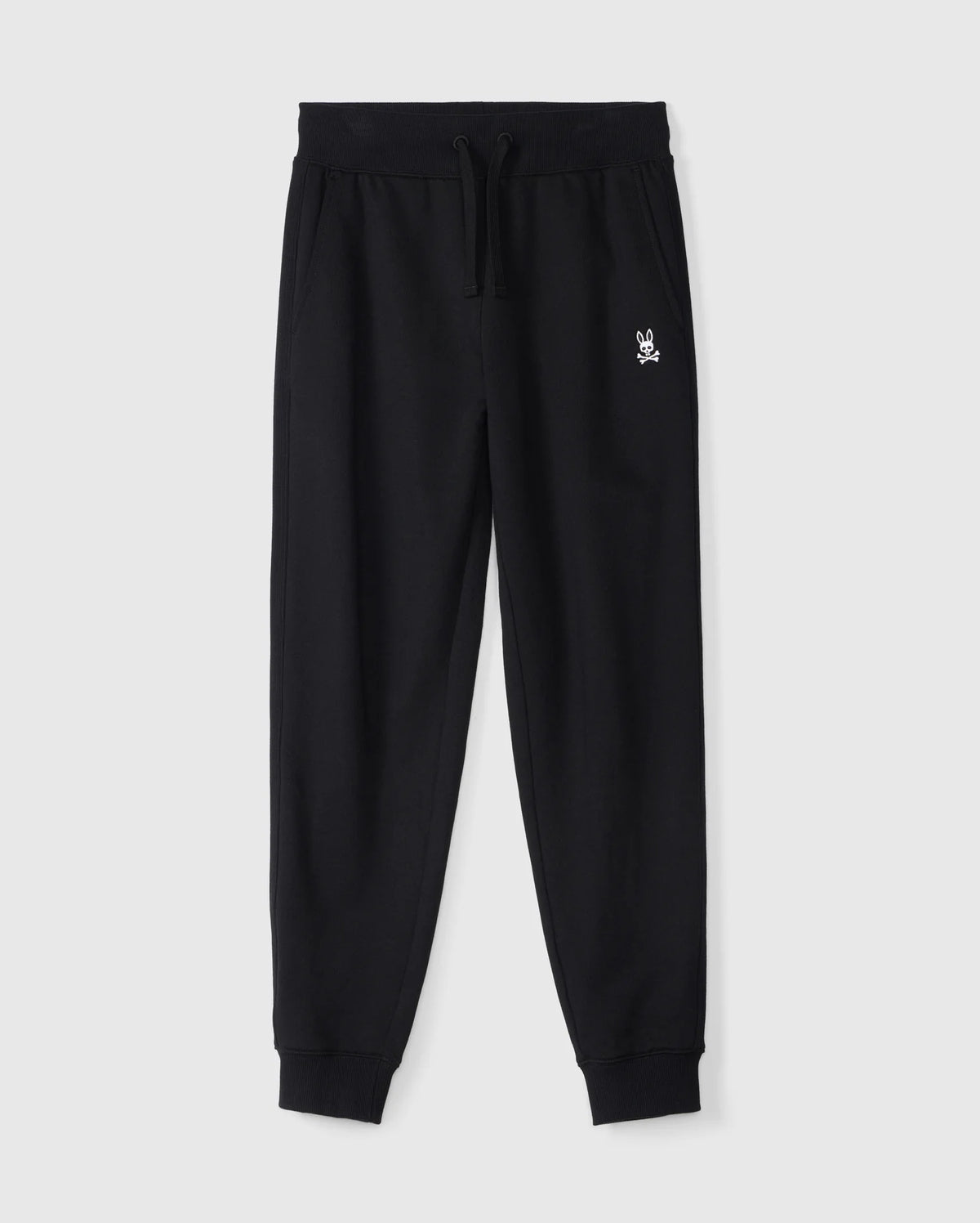 The KIDS LEVY ESSENTIAL FLEECE SWEATPANT - B0P721D200 by Psycho Bunny is a pair of black, 100% cotton sweatpants with an elastic waistband and drawstring, featuring a small white embroidered bunny logo on the left thigh. These cozy playtime pants have cuffed ankles and side pockets, making them ideal for active moments. They are displayed on a plain white background.