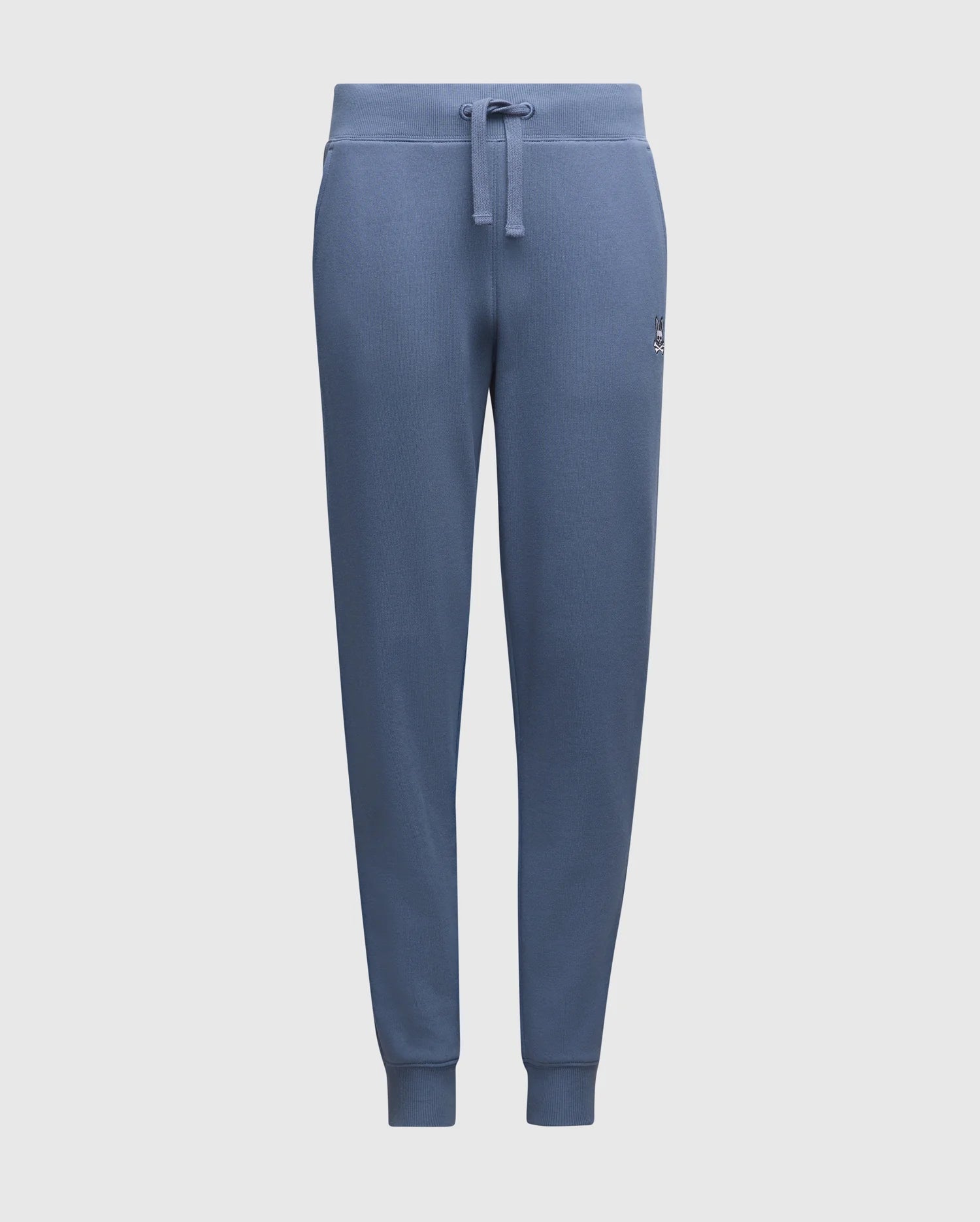 The KIDS LEVY ESSENTIAL FLEECE SWEATPANT - B0P721D200 by Psycho Bunny are blue cotton sweatpants featuring an elastic waistband, drawstring, small logo on the left thigh, tapered legs, and cuffed ankles for comfortable casual wear. They are set against a plain white background.