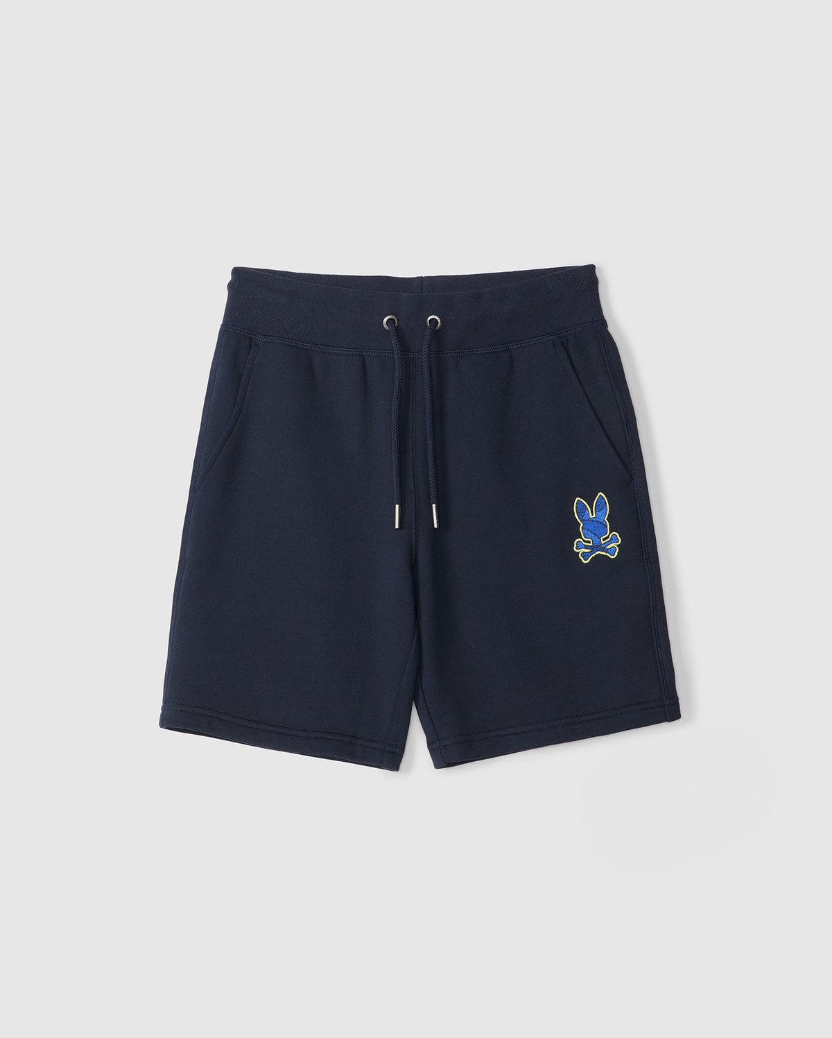 The KIDS LENOX SWEATSHORT by Psycho Bunny, in navy blue, is ideal for an active lifestyle with its drawstring waistband. Made from naturally breathable fleece, it features a small embroidered blue and yellow cartoon bunny with crossed bones on one leg, offering kids comfort and style.