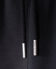 Close-up of black hoodie drawstrings with metallic aglets, crafted for ultimate comfort. The aglet on the right has "PSYCHO BUNNY" engraved on it, while the writing on the left aglet is partially obscured. Made from soft Micro French Terry material, it's perfect paired with KIDS LIVINGSTON TERRY SWEATSHORT - B0R408B200 by Psycho Bunny for a relaxed look.