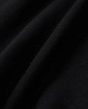 Close-up of black cotton blend fleece fabric with visible texture and soft folds. Light creates subtle highlights and shadows, emphasizing the Psycho Bunny KIDS LYONS SWEATSHORT - B0R578C200's fine details and quality.