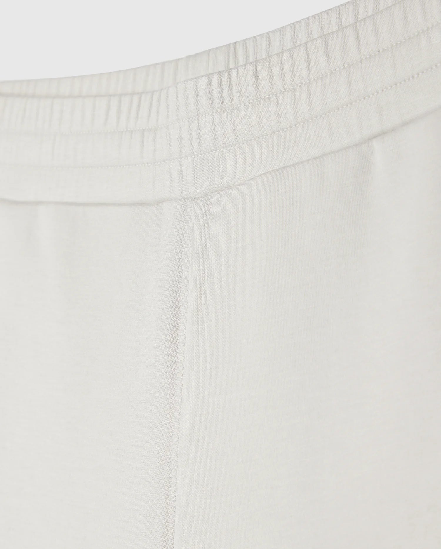 Close-up image of the upper part of a pair of Psycho Bunny KIDS LYONS SWEATSHORT - B0R578C200 showing the elastic waistband with gathered fabric. The soft stretch modal-cotton-blend jersey material appears smooth, indicating comfort and ease for everyday play. No additional details or design elements are visible.