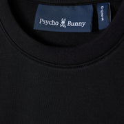 Close-up of a black KIDS HOUSTON FRENCH TERRY CREWNECK (B0S462C200) by Psycho Bunny, showcasing the collar and brand's label inside. Crafted from lightweight Micro French Terry, the label features the signature skull with bunny ears logo, exemplifying the premium cotton fabric quality.