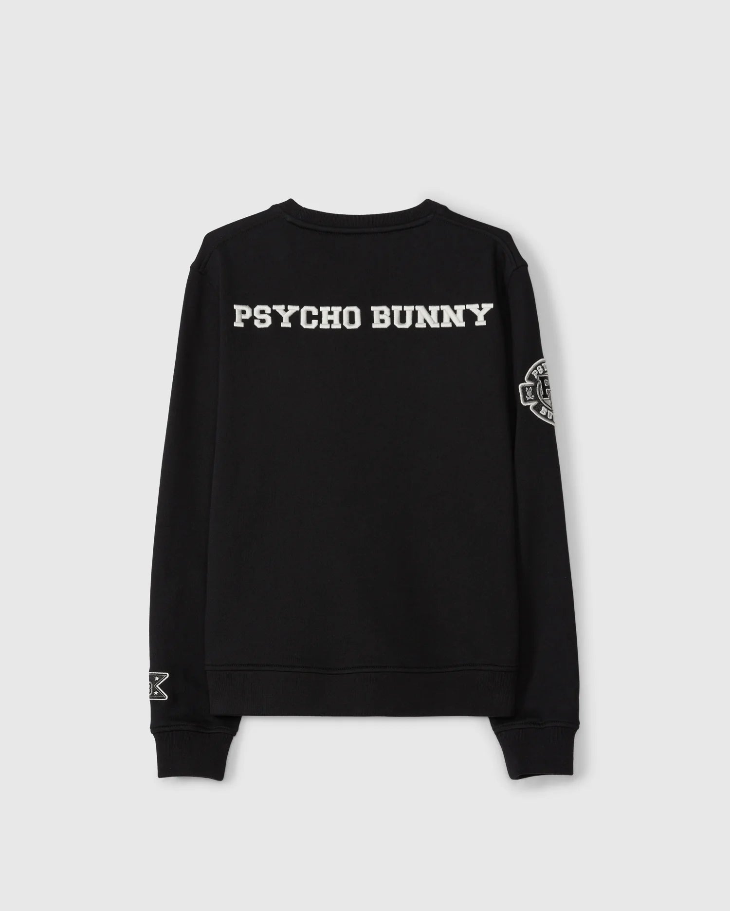The KIDS ZACK VARSITY SWEATSHIRT - B0S880D200 by Psycho Bunny is a black varsity sweatshirt that prominently displays "Psycho Bunny" in bold white lettering on the back, accompanied by a vintage-inspired logo with chenille embroidery on the left sleeve.