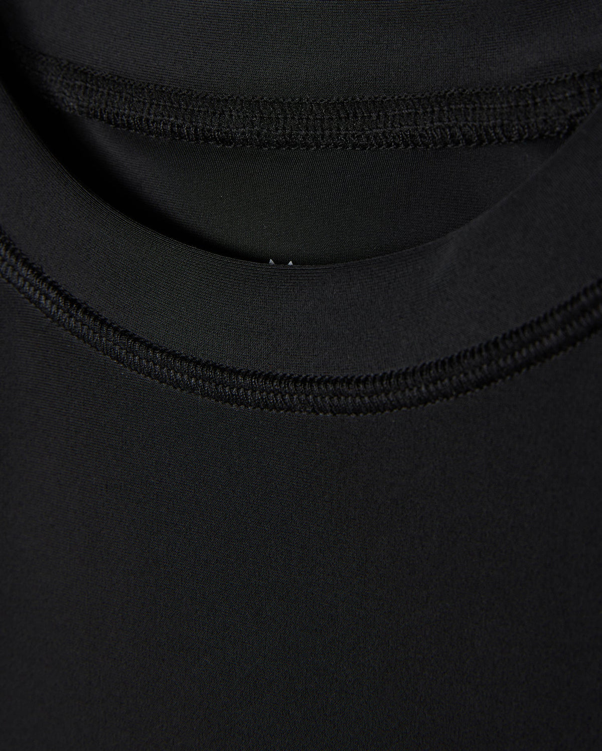 Close-up of a black fabric texture showing detailed stitching and overlapping layers, focusing on the craftsmanship and UPF 50+ protection quality in the Psycho Bunny KIDS SAN LEON ANTI-UV RASHGUARD - B0T645C200.