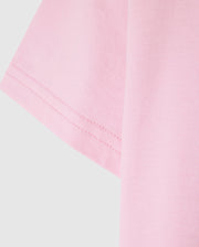 Close-up of the sleeve of a light pink Psycho Bunny KIDS CLASSIC CREW NECK TEE - B0U014CRPC against a plain background, showcasing the 100% Pima cotton fabric texture and stitching detail. An ideal pick for back-to-school outfits.