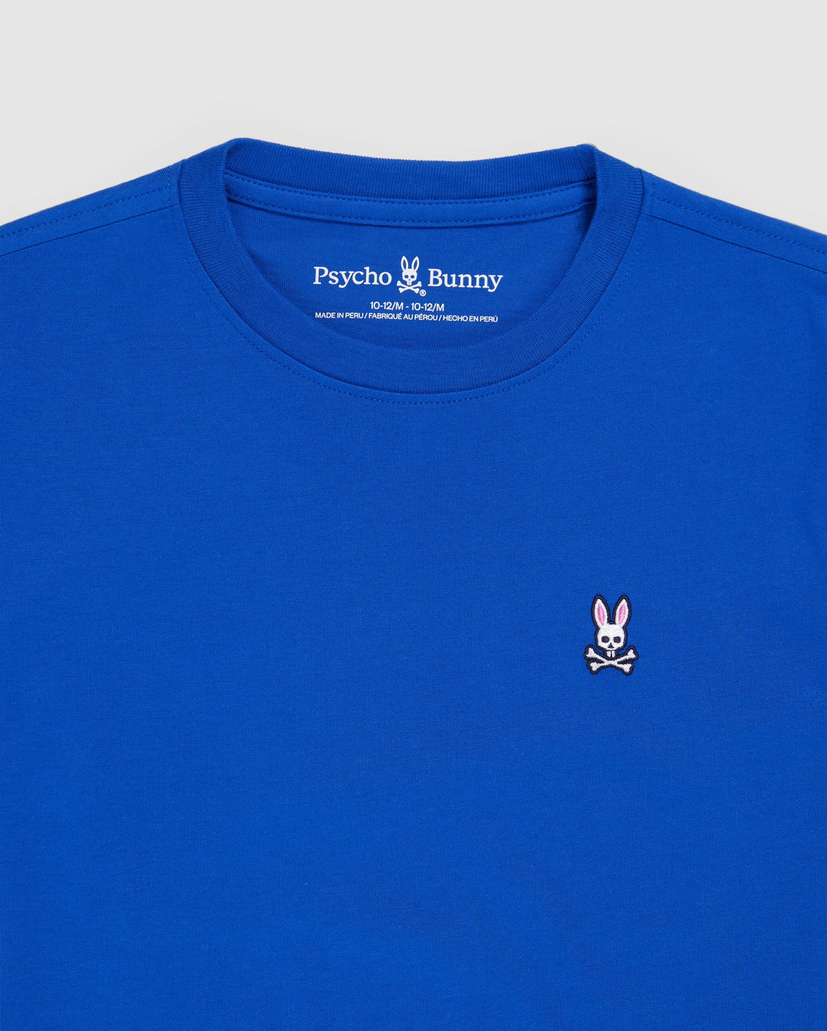 The KIDS CLASSIC CREW NECK TEE - B0U014CRPC by Psycho Bunny is a royal blue T-shirt crafted from soft Pima cotton. It features a small embroidered logo on the chest of a pink-eared bunny with crossbones, and the neckline label reads "Psycho Bunny," infusing playful style into this classic shirt.
