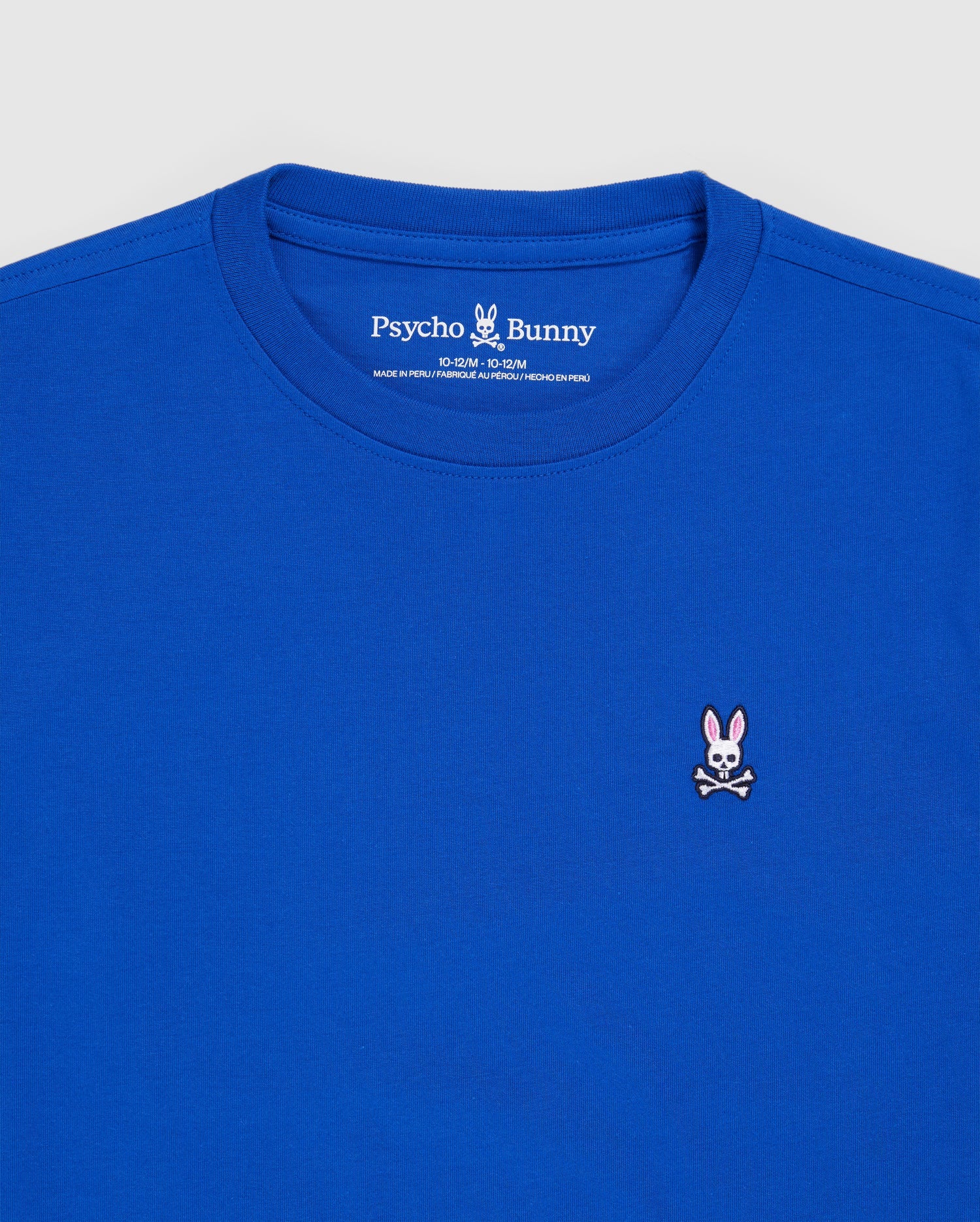 The KIDS CLASSIC CREW NECK TEE - B0U014CRPC by Psycho Bunny is a royal blue T-shirt crafted from soft Pima cotton. It features a small embroidered logo on the chest of a pink-eared bunny with crossbones, and the neckline label reads "Psycho Bunny," infusing playful style into this classic shirt.