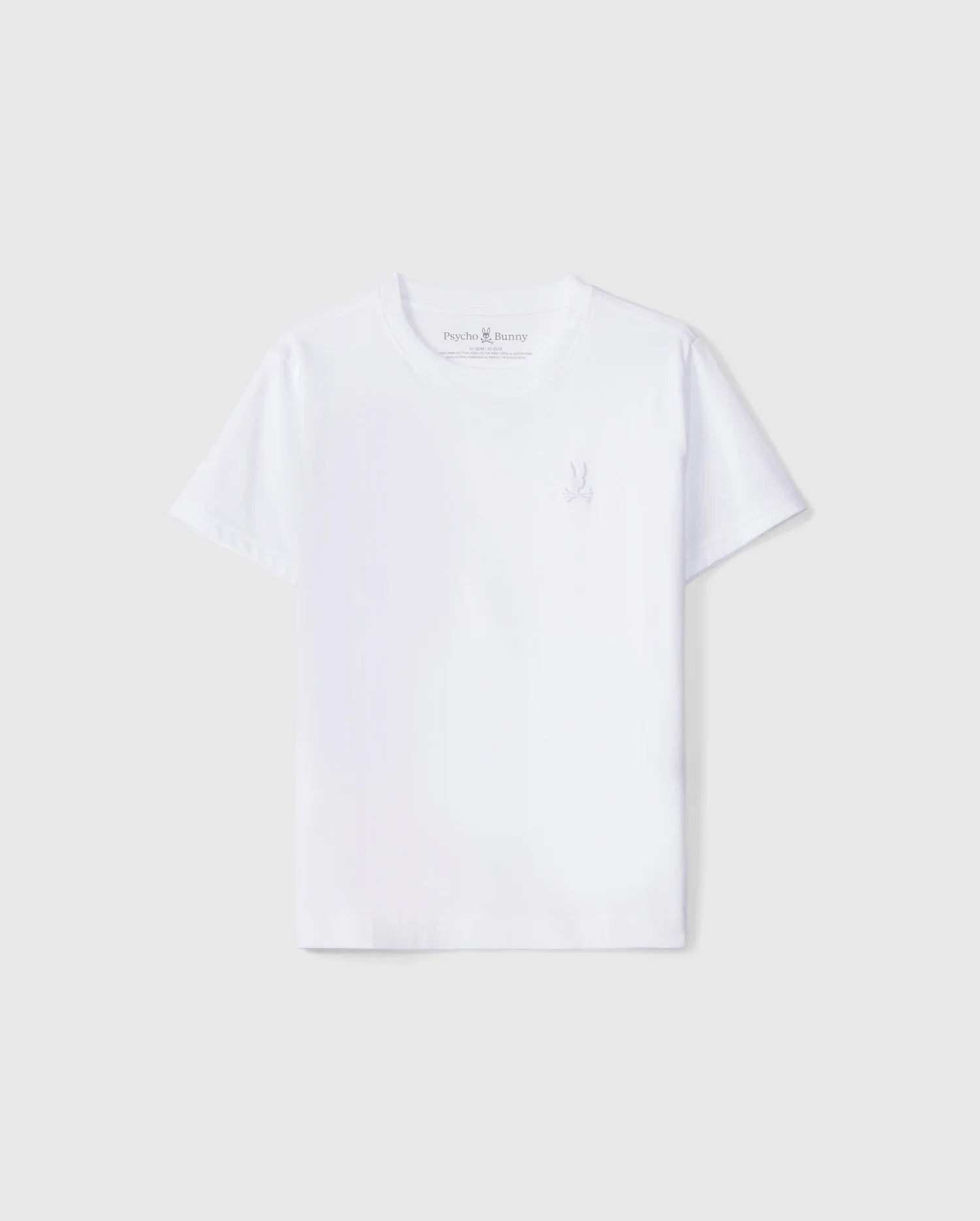 A plain white crew neck tee for kids, made from soft Peruvian Pima cotton with short sleeves. The KIDS EMBROIDERED CLASSIC TEE - B0U020AR00 features a subtle small embroidered Psycho Bunny logo on the left side of the chest. The background is a light grey.