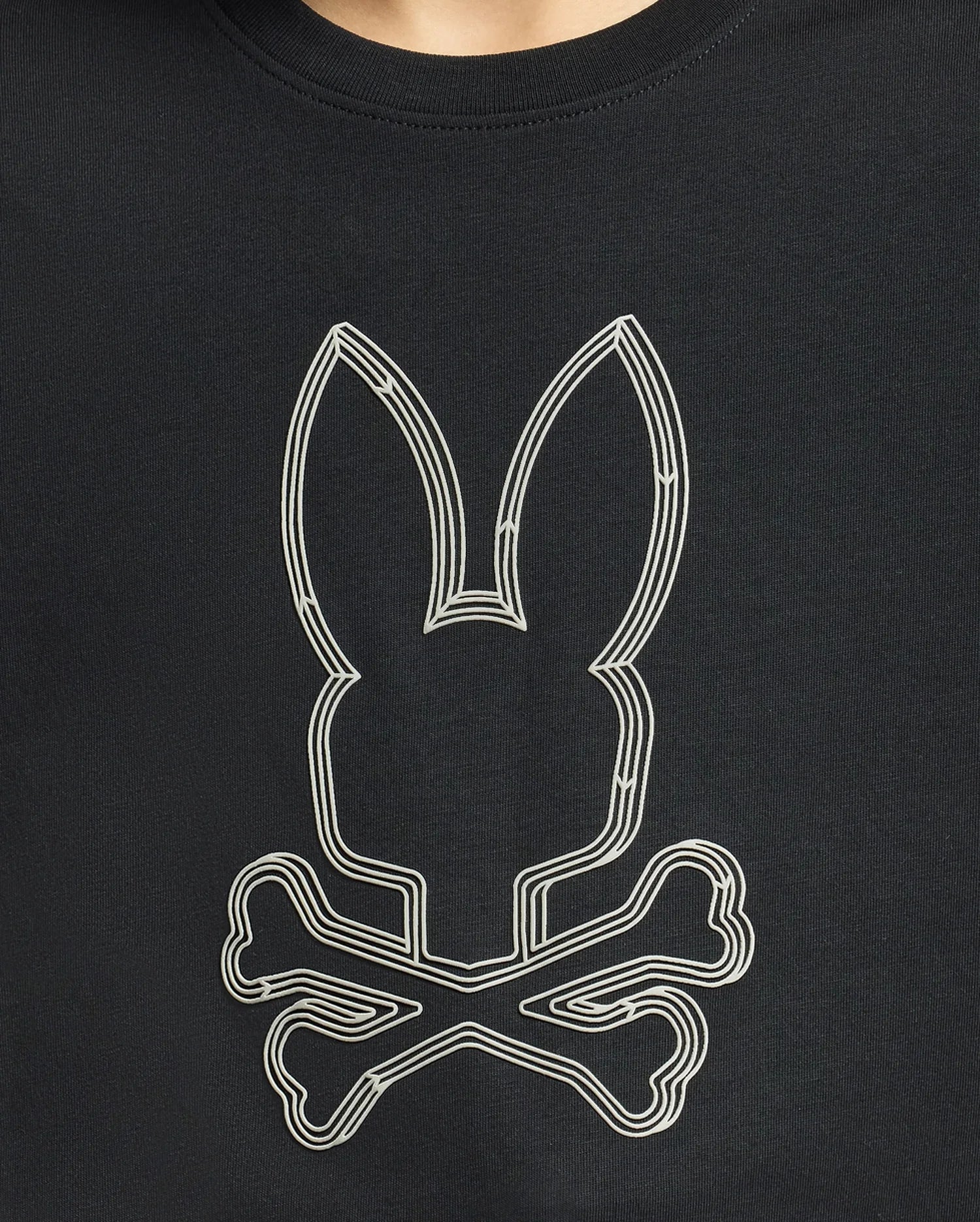 The KIDS MONARC FRONT BUNNY GRAPHIC TEE - B0U211E200 by Psycho Bunny is made from soft Pima cotton and features a minimalist monochrome design of a stylized rabbit head with elongated ears above two crossed bones. This edgy piece provides unparalleled comfort and style, making it perfect for any wardrobe.