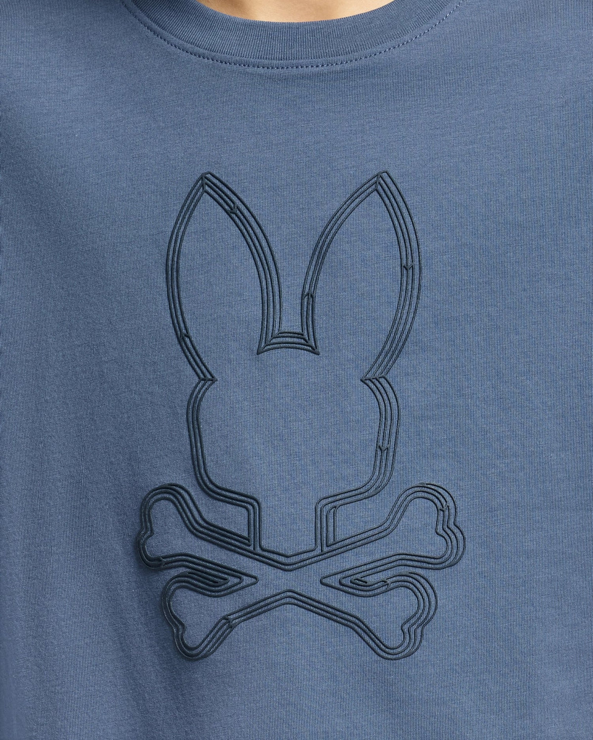 The KIDS MONARC FRONT BUNNY GRAPHIC TEE - B0U211E200 by Psycho Bunny showcases a blue shirt with an embossed Monarc Front Bunny design above crossbones. Crafted from soft Pima cotton, the simple yet stylized design adds a playful, edgy touch to the garment.