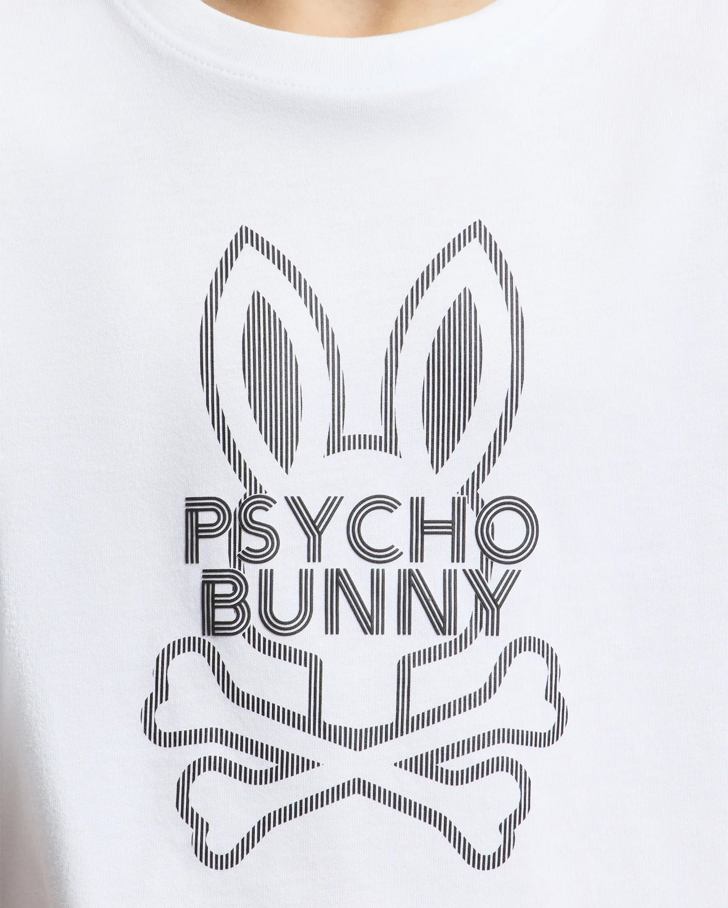 The KIDS DUMON GRAPHIC TEE by Psycho Bunny, made from soft Pima cotton, features a stylish white T-shirt design with an abstract rabbit head logo, elongated ears above crossed bones, and the bold text "Psycho Bunny" beneath.