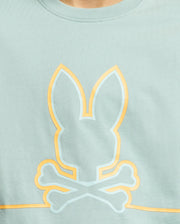 The KIDS DACANO FRONT GRAPHIC TEE by Psycho Bunny (B0U314E200) features a stylish light green color, showcasing a bunny head outline above crossed bones in a unique skull and crossbones style. The yellow and white graphic is centered on the chest, adding comfort-forward flair to this regular fit tee.