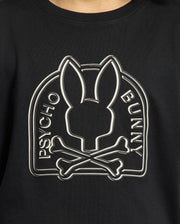 The KIDS MELBOURNE GRAPHIC TEE by Psycho Bunny, crafted from soft Pima cotton in black, showcases a stylized Bunny graphic with a bunny silhouette above crossed bones and "Psycho Bunny" elegantly displayed on either side.