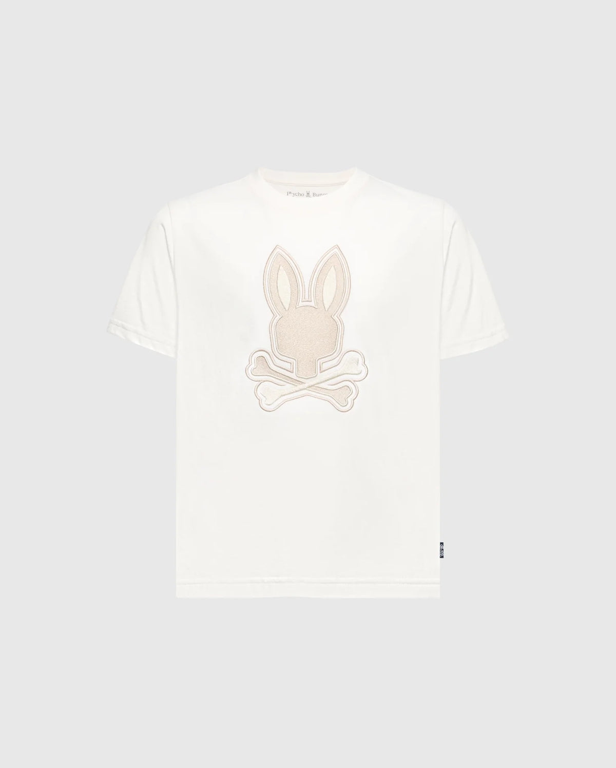Introducing Psycho Bunny's Kids New Castle Embroidered Graphic Tee (B0U415F200): A white Pima cotton T-shirt showcasing a beige embroidered rabbit's head with crossed bones on the front, creating a striking contrast against its plain gray background.