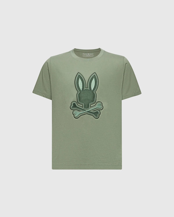The KIDS NEW CASTLE EMBROIDERED GRAPHIC TEE by Psycho Bunny is a khaki Pima cotton t-shirt with a two-tone bunny graphic—rabbit head above crossed bones—embroidered on the front.