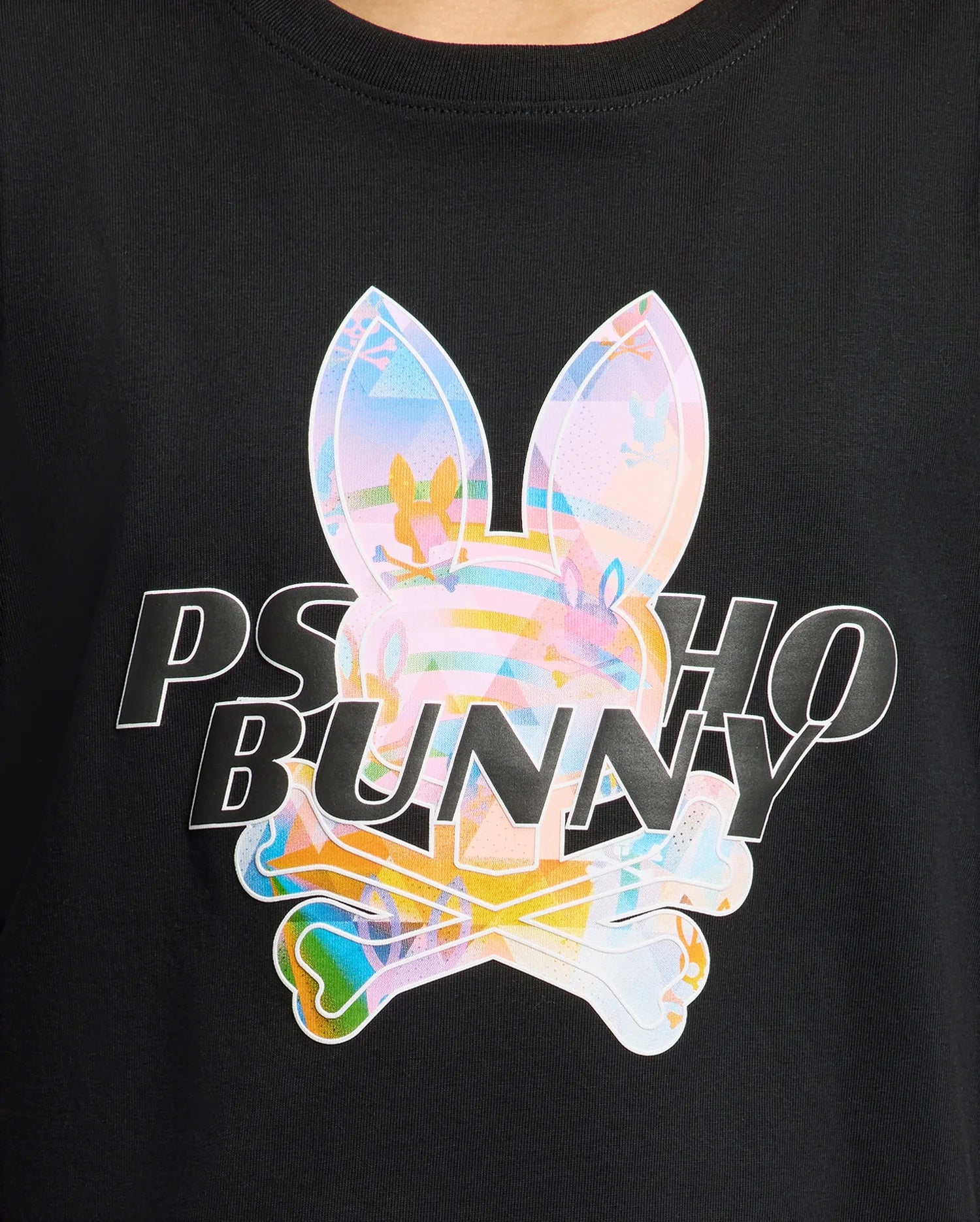 The Kids Milos Graphic Tee (B0U456F200) by Psycho Bunny is made from luxurious Peruvian Pima cotton and showcases the iconic "Psycho Bunny" logo with rabbit ears and crossbones. It features vibrant pastel hues and tropical patterns on a black background with a striking center bunny graphic.