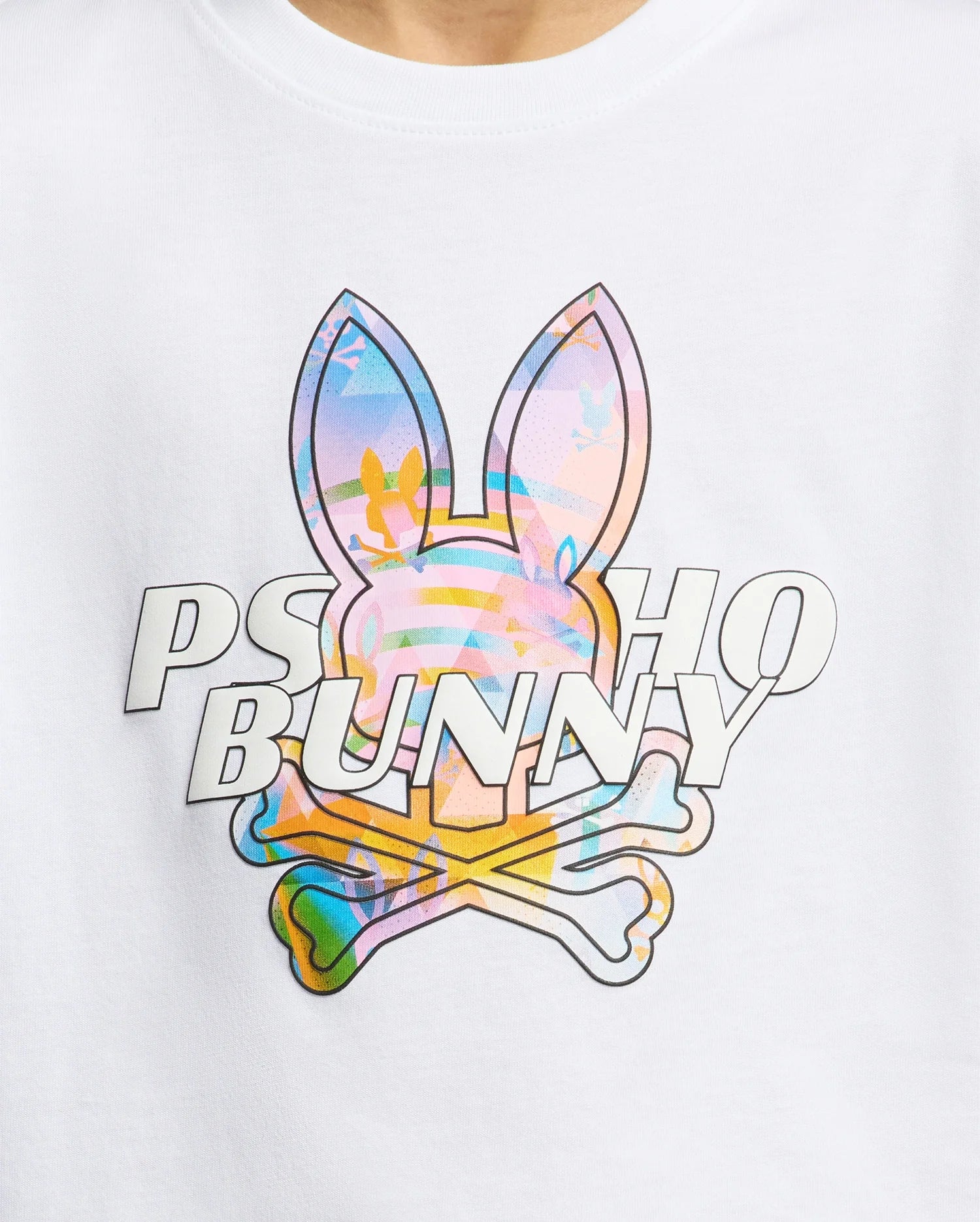 White jersey t-shirt featuring a large, vibrant multi-color abstract Psycho Bunny skull graphic print on the chest, with raised white PSYCHO BUNNY text overlay.
