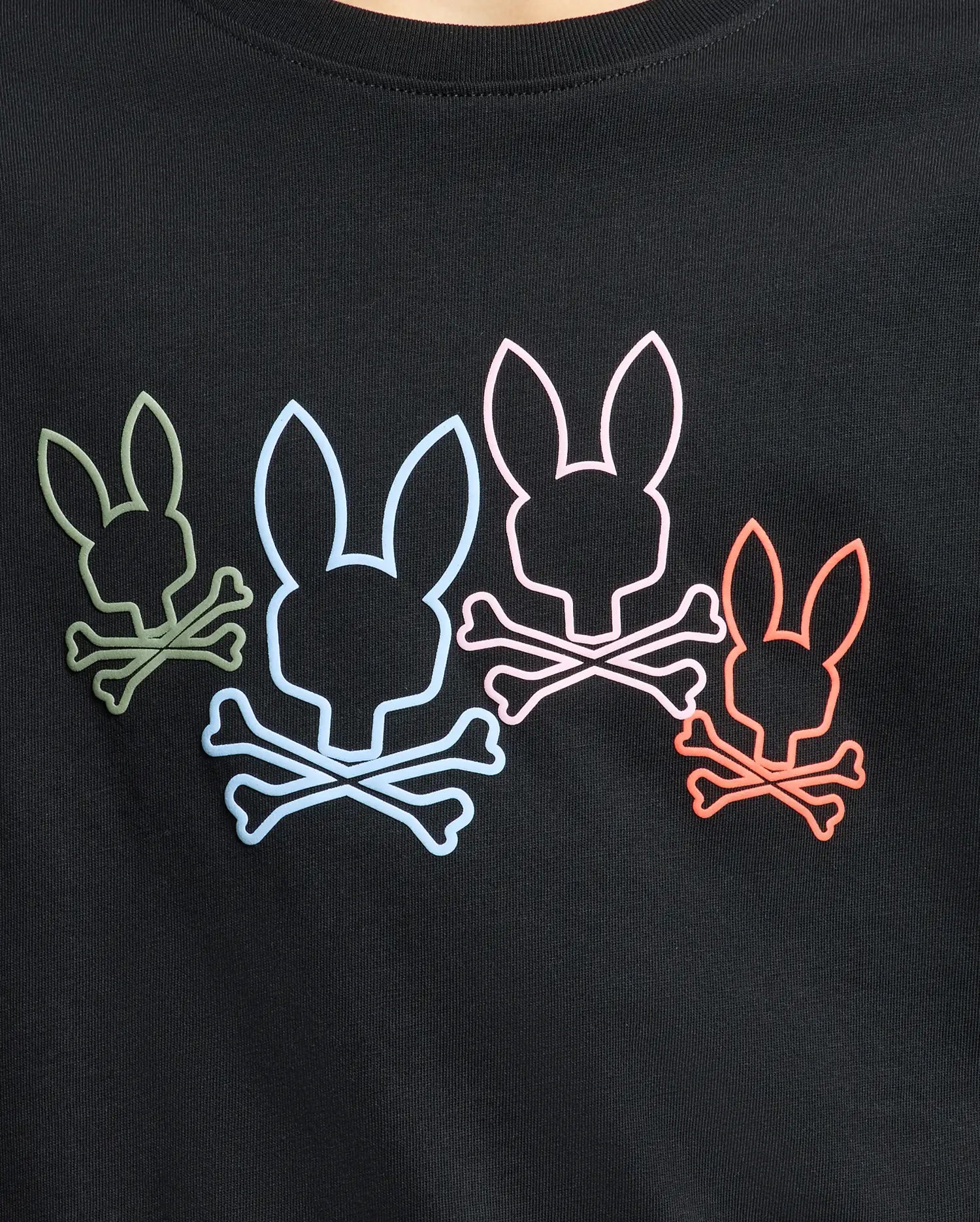 The Psycho Bunny KIDS SILVERDALE GRAPHIC TEE (B0U499F200) features a unique graphic of four skull-like bunnies with crossbones in vibrant green, blue, pink, and red on a black background. Made from soft Pima cotton with a water-based print for long-lasting vividness.