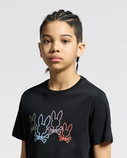 A person with braided hair wears the Psycho Bunny KIDS SILVERDALE GRAPHIC TEE featuring a vibrant bunny skull design on a black Pima cotton fabric, standing out against the plain gray background.