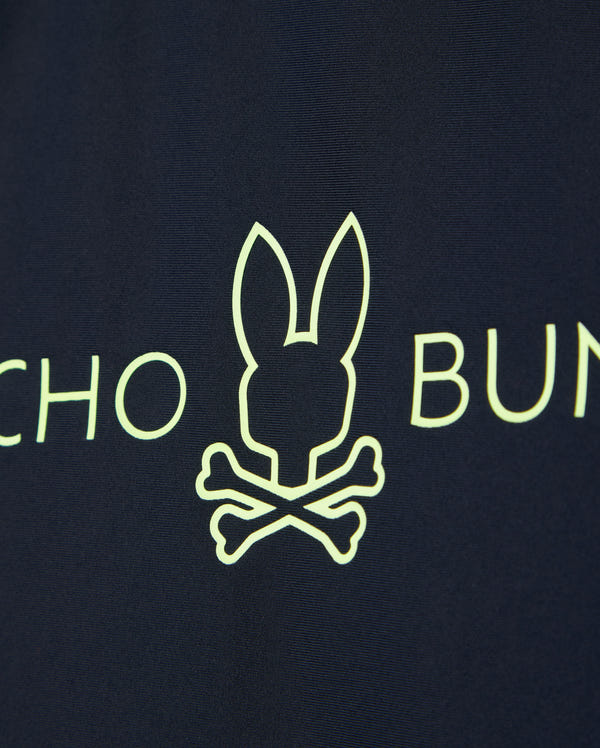 Navy blue fabric of the KIDS SHORT SLEEVE RASH GUARD - B0U558C200 by Psycho Bunny features a neon yellow bunny head above crossed bones with partial text on either side.