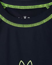 A close-up of the Psycho Bunny KIDS SHORT SLEEVE RASH GUARD in navy blue featuring lime green stitching around the neckline and a partial logo with a stylized animal design near the center.