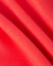 Close-up of bright red fabric with a smooth texture, perfect for a kids' fashion tee. The Pima cotton displays natural folds and subtle variations in shade, adding depth and movement. The weave is slightly visible, creating a hint of pattern on this vibrant material, ideal for an embroidered chest Bunny design. The KIDS KAYDEN FASHION TEE - B0U577C200 from Psycho Bunny exemplifies these qualities beautifully.