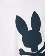Close-up of a white Psycho Bunny Pima cotton T-shirt featuring a large black silhouette of a stylized rabbit head and crossed bones, resembling a pirate motif.