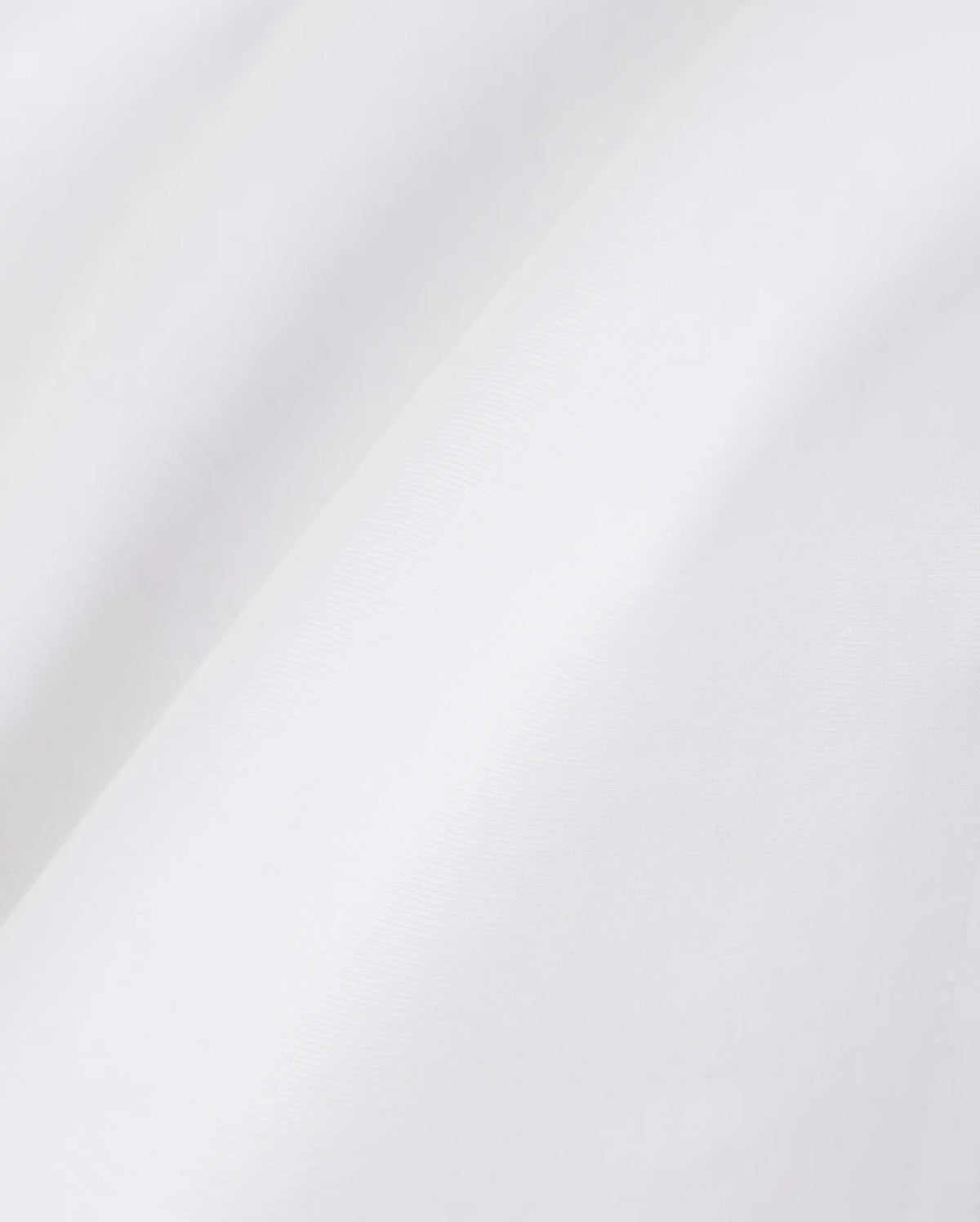 Close-up view of a textured Psycho Bunny Pima cotton fabric illustrating subtle folds and shadows, conveying a smooth and fine material quality.