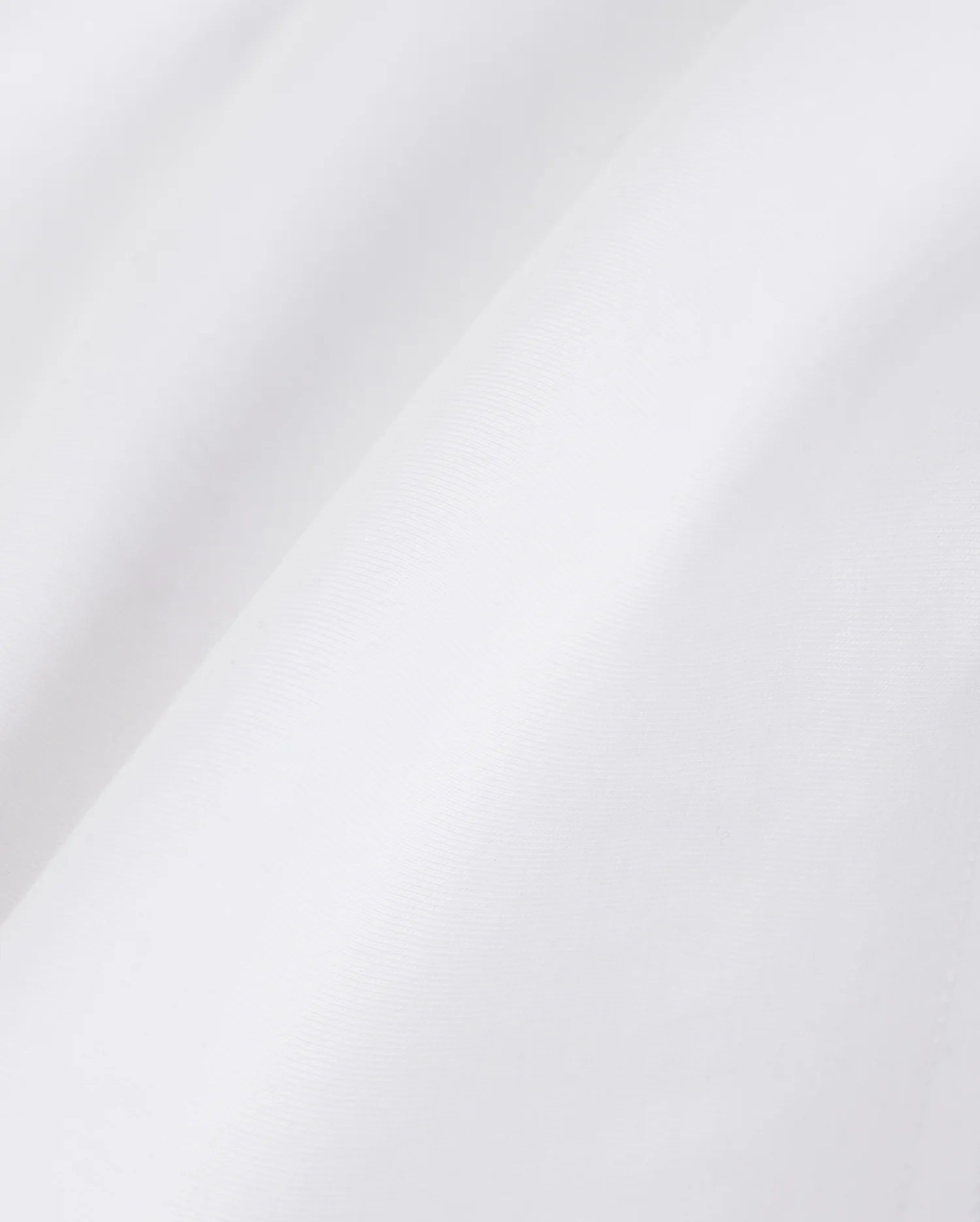 Close-up view of a textured Psycho Bunny Pima cotton fabric illustrating subtle folds and shadows, conveying a smooth and fine material quality.