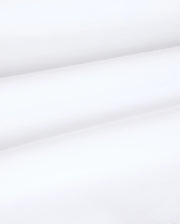 Close-up image of the Kids Vincent Graphic Tee - B0U713D200 by Psycho Bunny, showcasing its smooth, white fabric with subtle diagonal lines and horizontal folds. The texture appears soft and lightweight, reminiscent of the luxurious feel of Pima cotton—perfect for creating unfadable style in children's clothing.