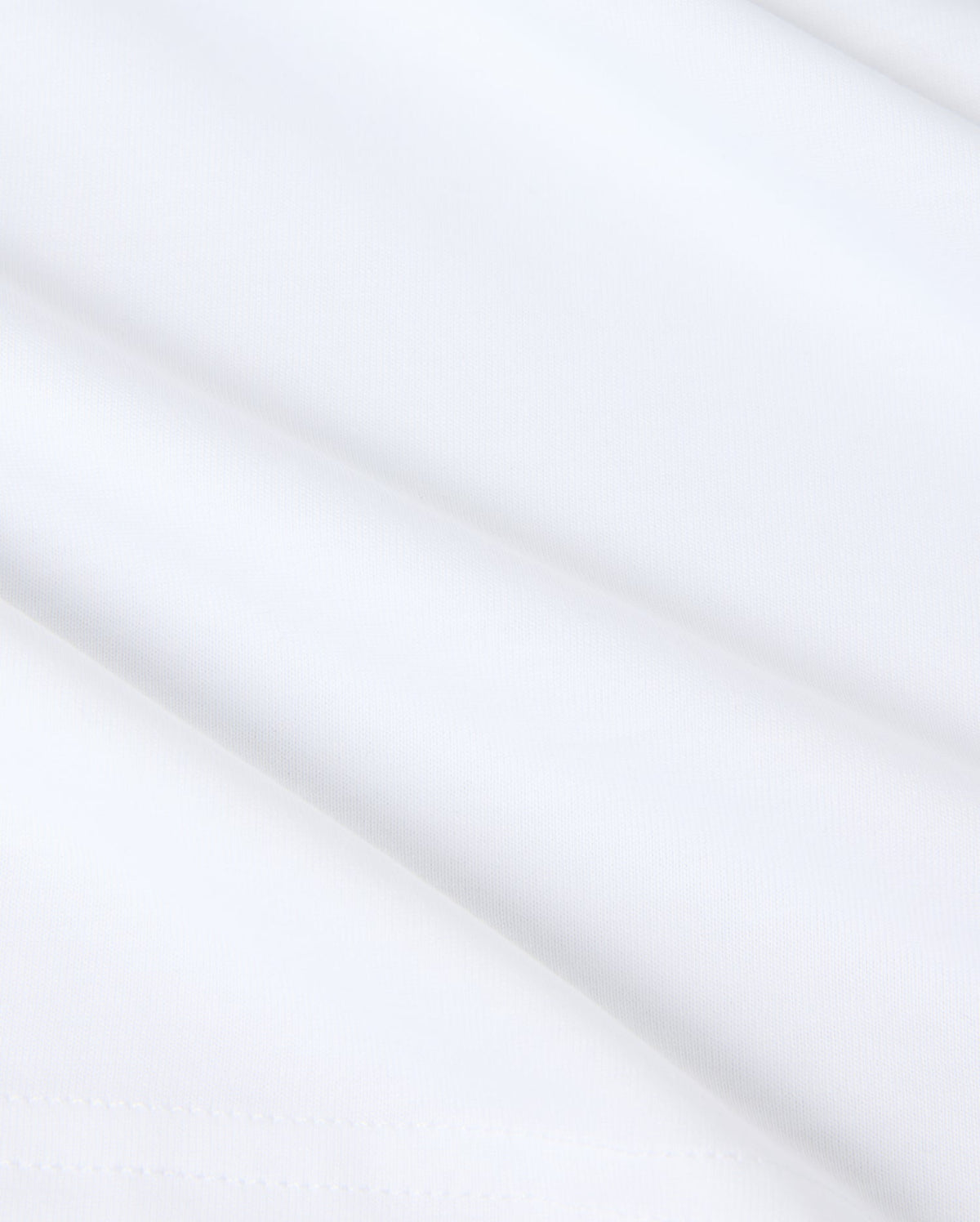 Close-up of smooth white fabric with subtle shadows, featuring a slightly folded surface. Made from Pima cotton, the texture appears soft and light, evoking a sense of simplicity and purity reminiscent of a Psycho Bunny KIDS KINGSTON GRAPHIC TEE - B0U743D200.