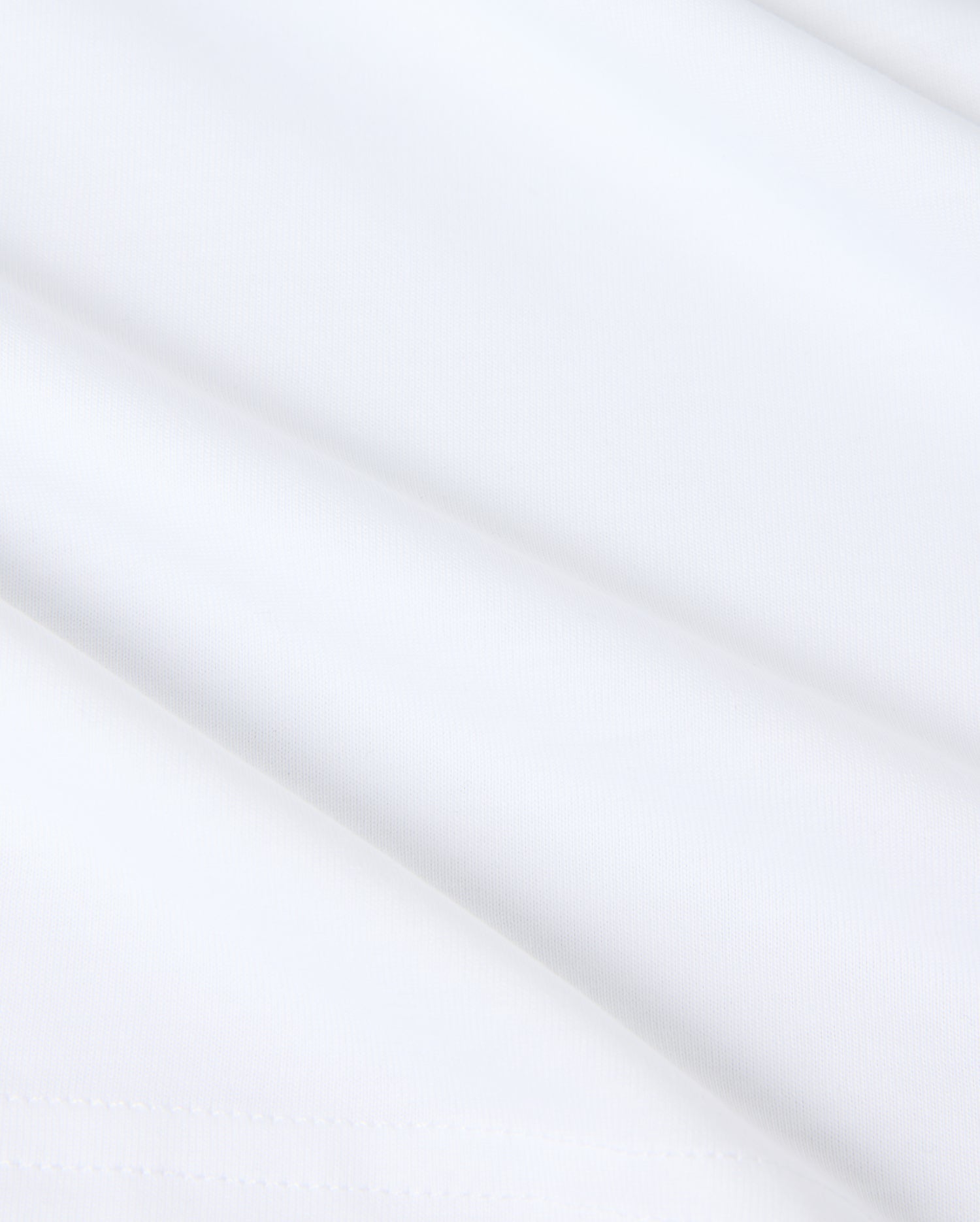 Close-up of smooth white fabric with subtle shadows, featuring a slightly folded surface. Made from Pima cotton, the texture appears soft and light, evoking a sense of simplicity and purity reminiscent of a Psycho Bunny KIDS KINGSTON GRAPHIC TEE - B0U743D200.