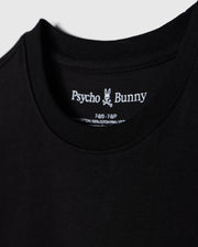 Close-up of a black t-shirt, showcasing the brand name "Psycho Bunny" and a small bunny skull logo inside the collar. Details include shirt size and material info, made from 100% Peruvian Pima cotton. The soft and smooth fabric highlights its premium quality. This particular piece is identified as the "KIDS LOS ANGELES CITY TEE - B0U861A2PC".