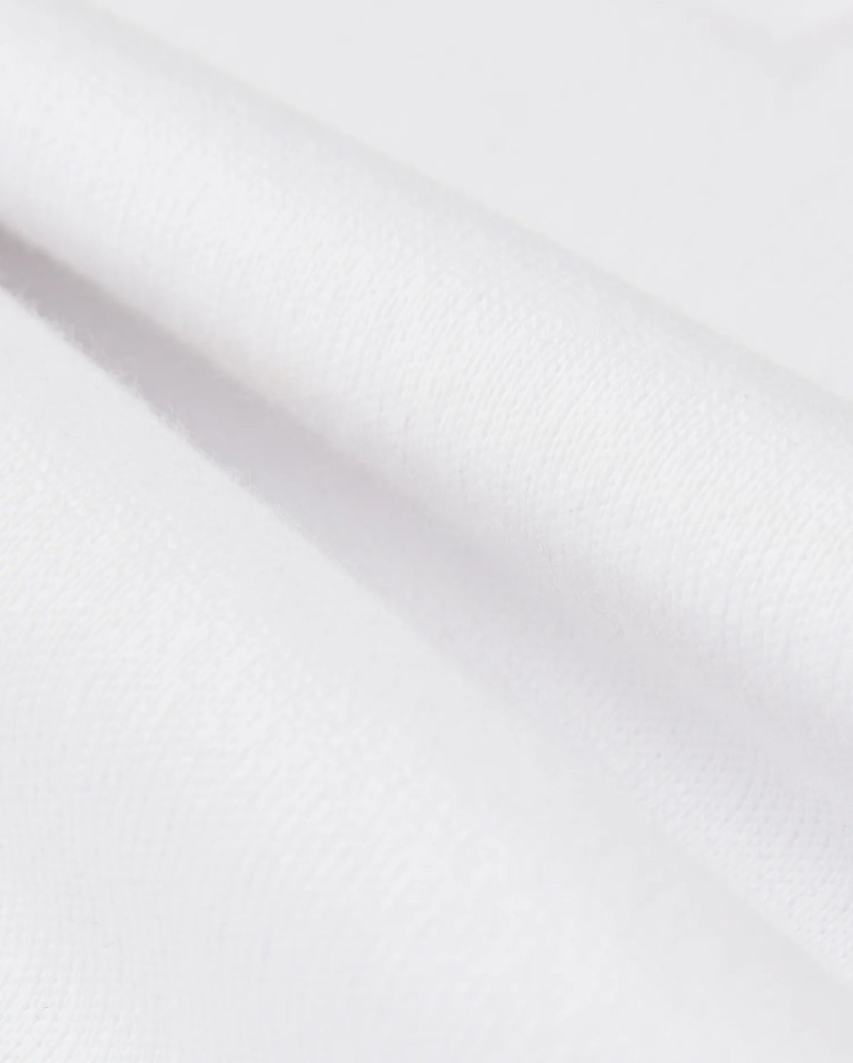 Close-up of smooth, white Pima cotton with soft folds, highlighting the clean texture of a Psycho Bunny KIDS LONDON RAGLAN GRAPHIC TEE - B0U896D200.
